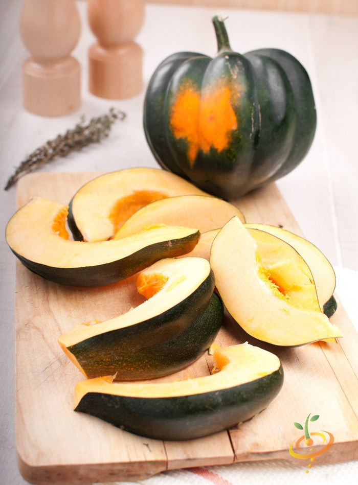 Winter acorn squash from SeedsNow, showing vibrant green and orange acorn-shaped squash on a garden table.