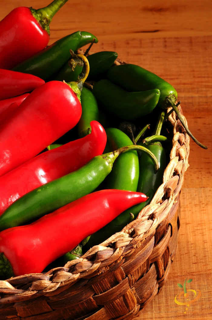 Basket of red and green Serrano Tampiqueño peppers on wooden surface